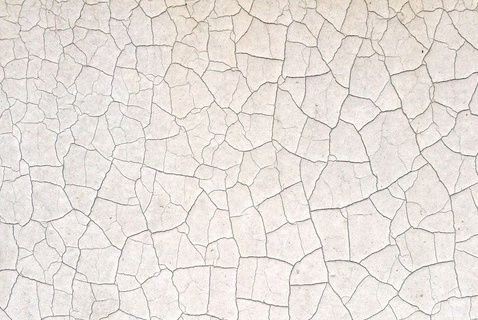 A wall with cracked white paint.