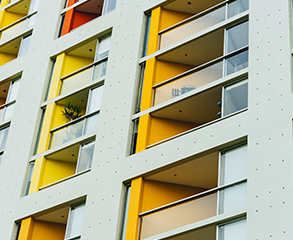 White hotel exterior with balconies painted various shades of yellow.