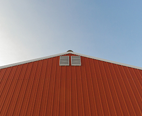 The side of an industrial facility painted red.