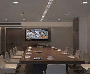 A modern conference room with grey and brown painted walls, large wood doors, a flat screen TV on the wall, and a large dark brown wood conference table with white cups on it and white color chairs around it.