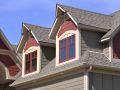 Bright red painted windows and salmon red details on gable dormers.