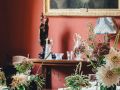 Red luxury dining room interior with two bouquets of flowers on the table, renovated by Pro Painters.