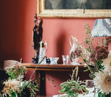 Red luxury dining room interior with two bouquets of flowers on the table, renovated by Pro Painters.